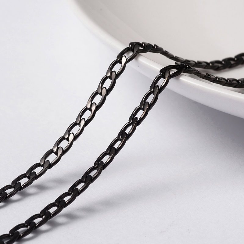 Black twisted metal jewellery chain figaro link pattern matte black finish draped over white bowl jewellery making Australia