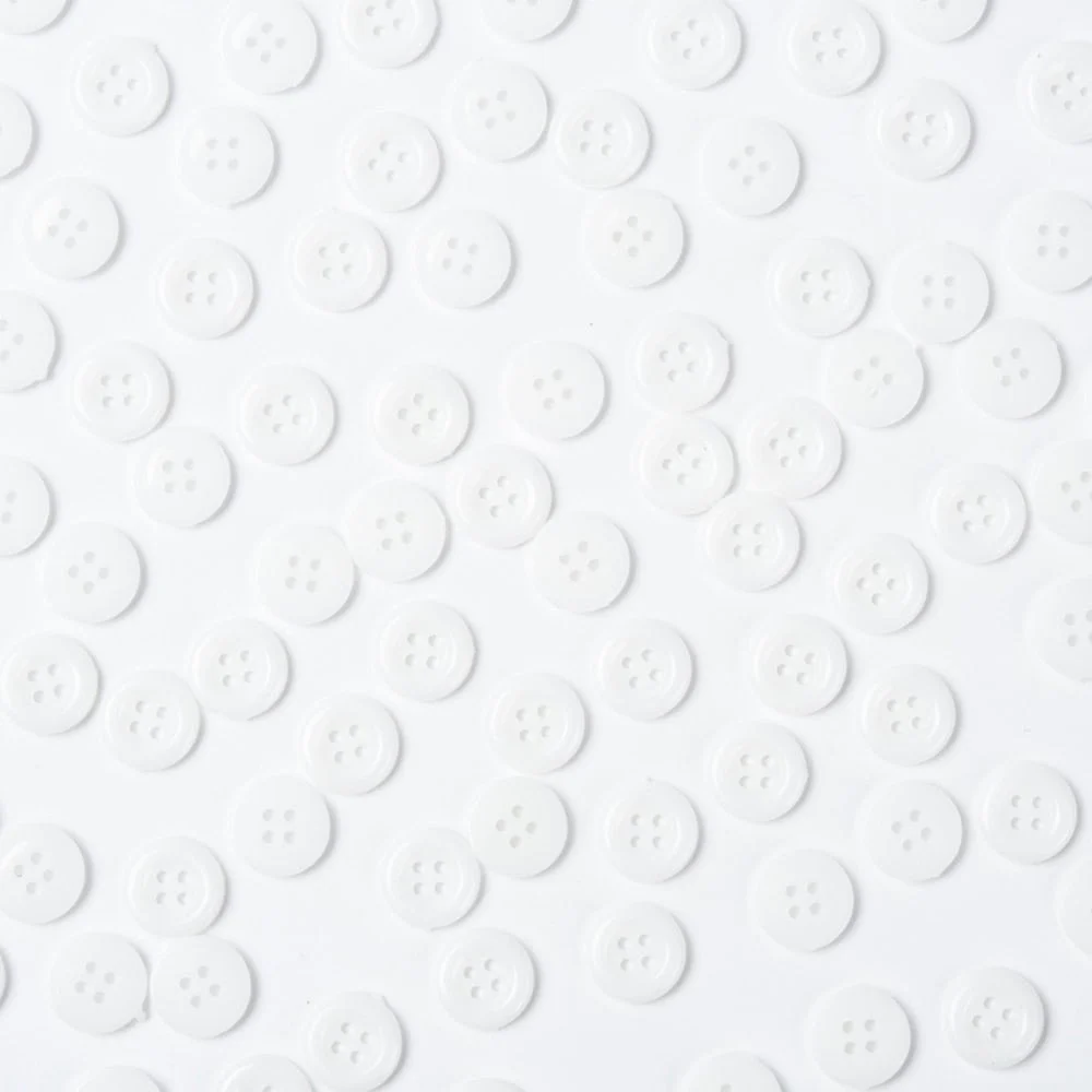 White acrylic 4 hole costume design buttons glossy finish raised rim scattered on grey background craft sewing Australia