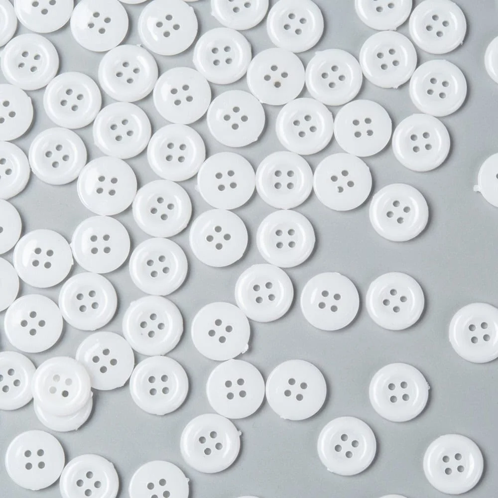White acrylic 4 hole costume design buttons glossy finish raised rim scattered on grey background craft sewing Australia